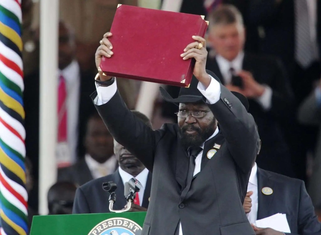 H.E. President Salva Kiir Mayardit raises the official state volume above the green presidential podium at an outdoor national event
