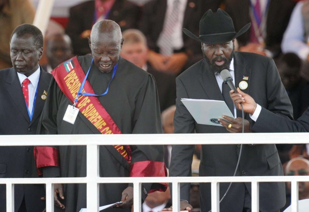 Formal state ceremony: H.E. President Salva Kiir Mayardit at the microphone with the President of the Supreme Court in judicial robes, national flag on the ceremonial sash